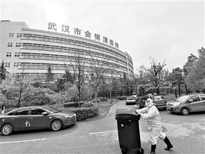2月29日,一名医务人员推着垃圾桶在武汉市金银潭医院住院楼前走过.